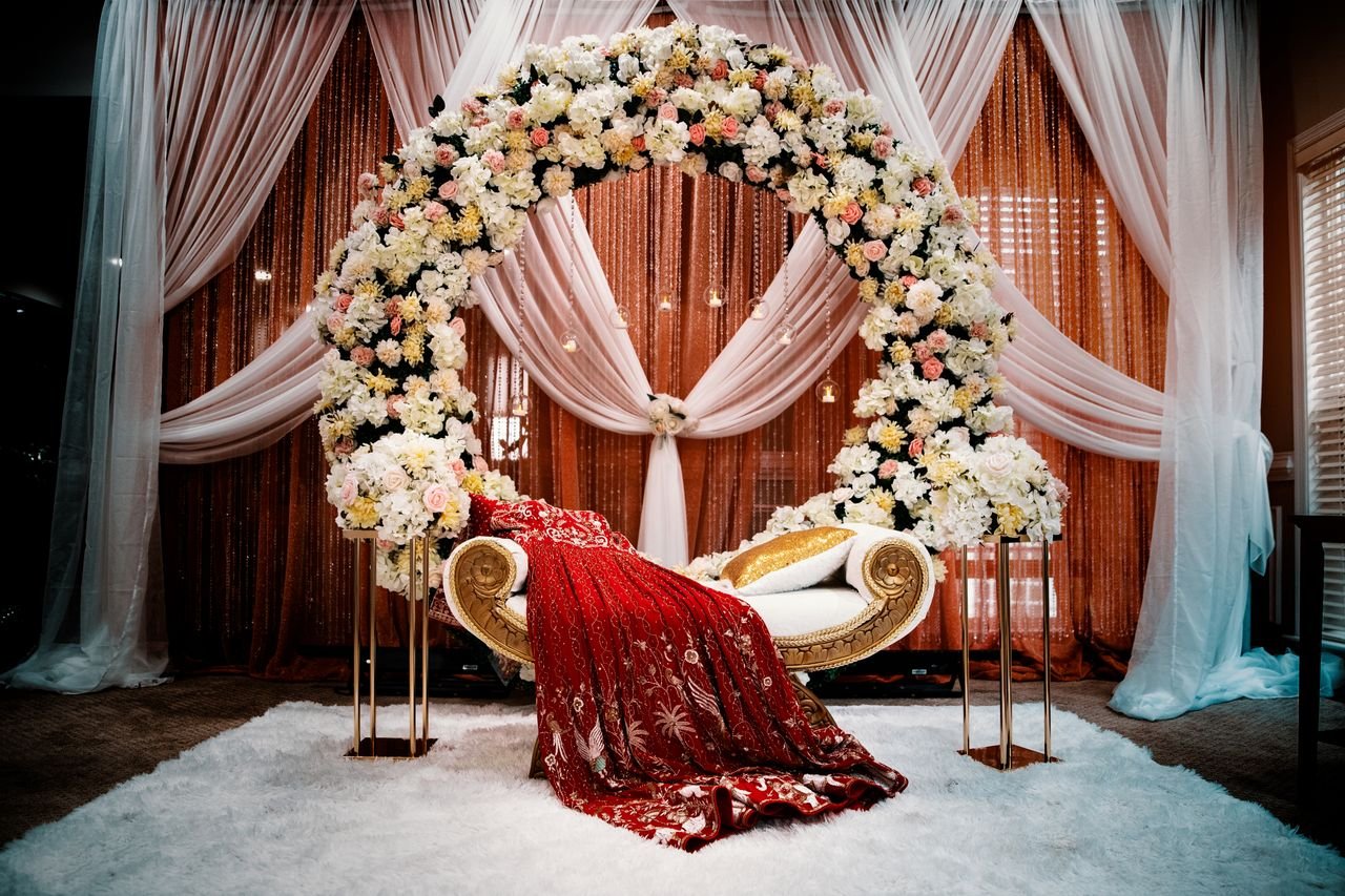 services-01 Luxurious wedding stage featuring a floral arch and traditional attire, ideal for ceremonies.